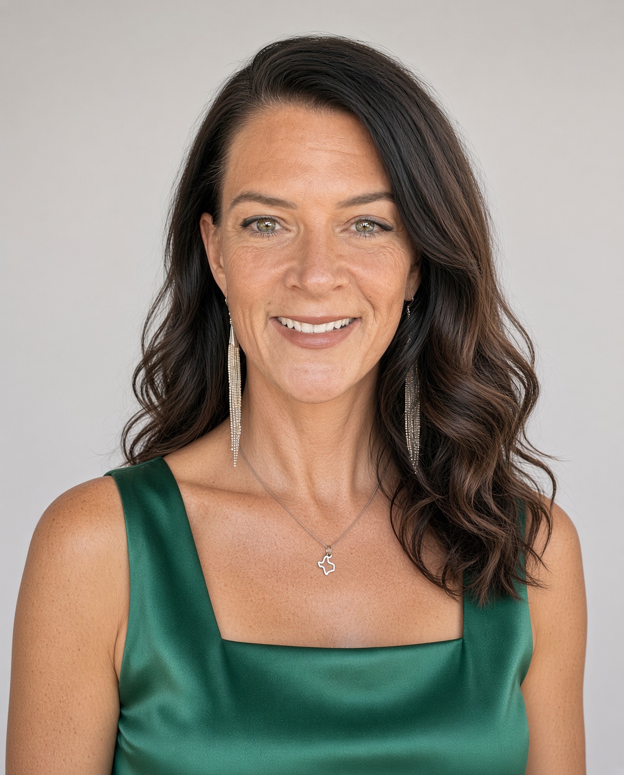 Jill, smiling, in a green satin top against a light background